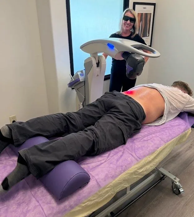 Dr. Shona treating a patient’s lower back with the MLS M7 laser